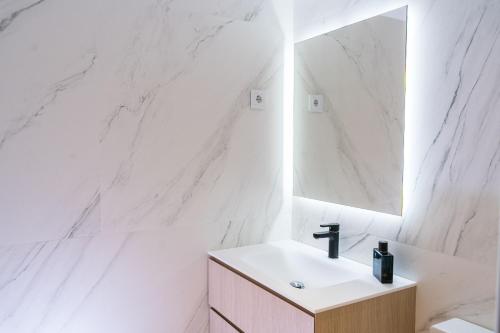 a white bathroom with a sink and a mirror at Airoto by Totiaran in Baqueira-Beret