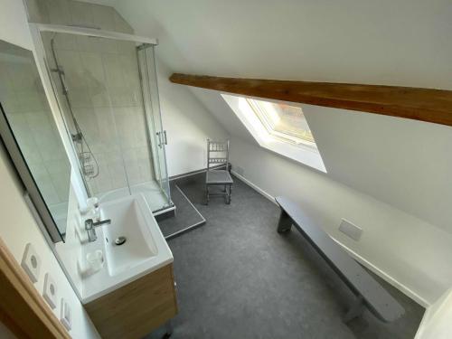 an attic bathroom with a sink and a window at À la ferme de Thilloy in Ligny-Thilloy