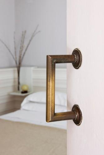 a gold door handle on a white door with a bed at Riva Lofts Florence in Florence