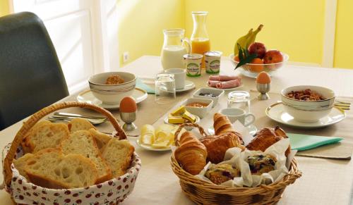 une table recouverte de pain et un panier de nourriture dans l'établissement Champ De Foire, à Sussac