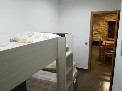 a bunk bed in a room with a table at Vivienda de uso turístico, A Casa Do Campo in Fisterra