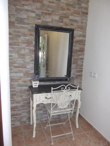 a mirror on a brick wall with a white dressing table at LUXURIOUS APPARTMENTS KATERINA in Platamonas