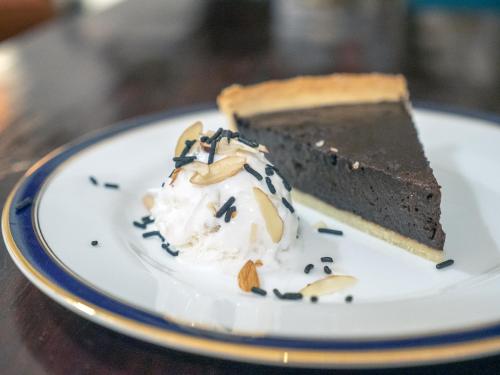 a piece of chocolate cake and whipped cream on a plate at Le Colonial 1506 - Exclusive Luxury Hideaway in Cochin