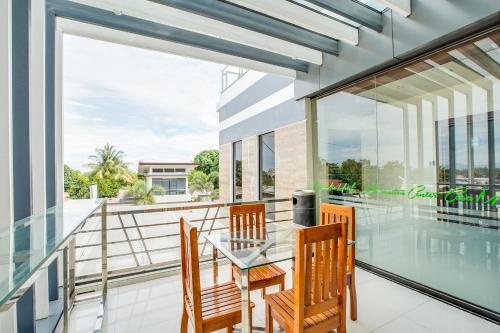 uma sala de jantar com uma mesa de vidro e cadeiras numa varanda em OYO 489 Casa Mia Hotel Suites em General Santos