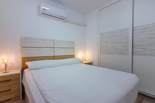 a white bed in a white bedroom with two lamps at Amazing view FREE WIFI in Callao Salvaje