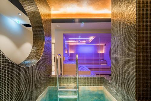 a pool in a bathroom with purple lighting at Zeller-Hotel+Restaurant in Kahl am Main