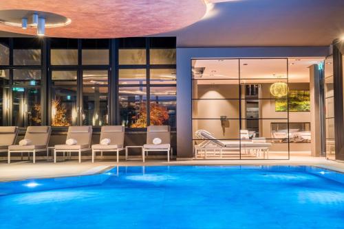 a pool in a hotel with chairs and a swimming pool at Zeller-Hotel+Restaurant in Kahl am Main