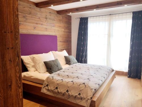 um quarto com uma cama e uma parede de madeira em The LODGE, Saalbach em Saalbach-Hinterglemm