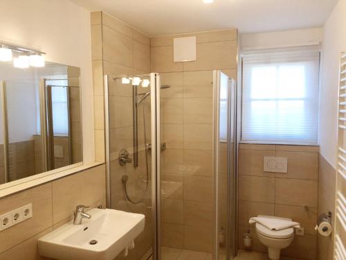 a bathroom with a shower and a sink and a toilet at The LODGE, Saalbach in Saalbach-Hinterglemm