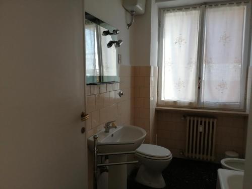a bathroom with a sink and a toilet and a window at Appartamento Beatrice in Pistoia