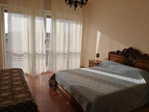 1 dormitorio con 1 cama y una ventana con cortinas en Appartamento Beatrice, en Pistoia