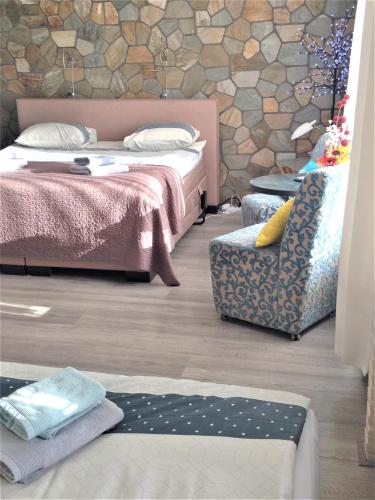 a bedroom with two beds and a chair at Westerschelde B&B in Vlissingen