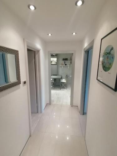 a hallway with white walls and white tile floors at Via Corso in Rijeka