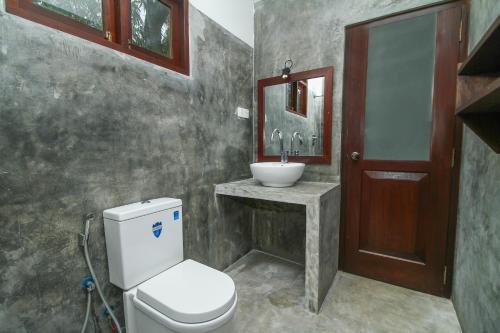 a bathroom with a toilet and a sink at Villa 45 - Balapitiya in Balapitiya