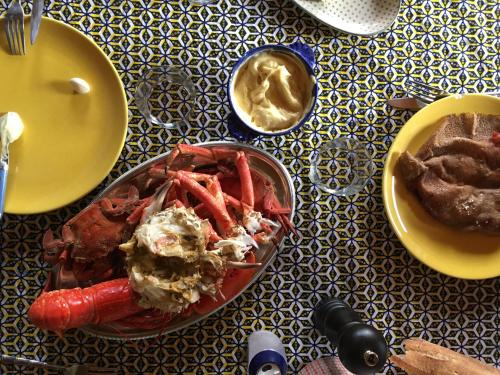 een tafel met een bord kreeft en ander eten bij Gîte de Kereveur, Loguivy de la Mer in Ploubazlanec