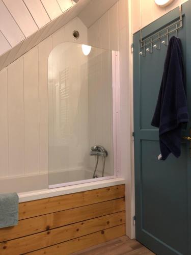 een badkamer met een bad en een douche met een glazen deur bij Gîte de Kereveur, Loguivy de la Mer in Ploubazlanec