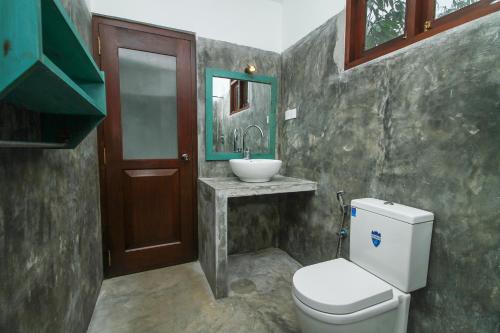 a bathroom with a toilet and a sink at Villa 45 - Balapitiya in Balapitiya