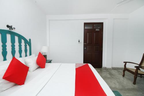 a bedroom with a bed with red pillows on it at Villa 45 - Balapitiya in Balapitiya