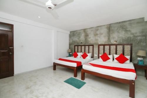 two beds with red pillows in a room at Villa 45 - Balapitiya in Balapitiya