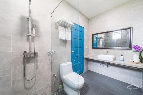 a bathroom with a shower and a toilet and a sink at Villa Alaya Malai in Setiu