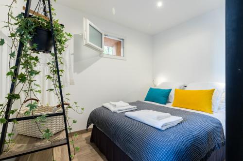 um quarto com uma cama com almofadas coloridas e uma escada em Le Clemenceau em Antibes
