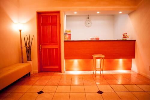 a room with a bar with a chair and a red door at Tachikawa Regent Hotel in Tachikawa