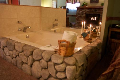 a bathroom with a bath tub with candles and a fireplace at Sleepy Forest Cottages in Big Bear Lake