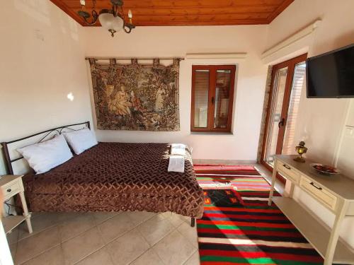 a bedroom with a bed and a flat screen tv at Sophia's Stone House in Dhimitsana