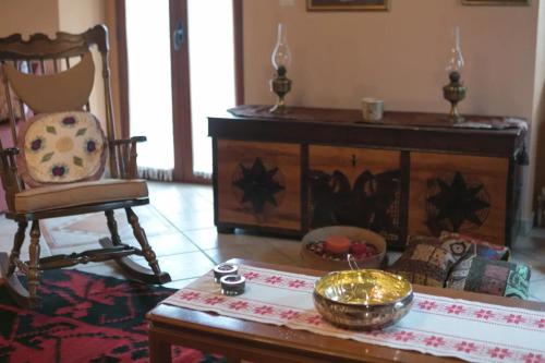 a living room with a table and a chair at Sophia's Stone House in Dhimitsana