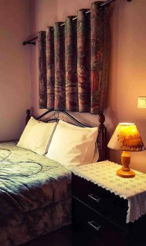 a bedroom with a bed with a headboard and a lamp at Sophia's Stone House in Dhimitsana