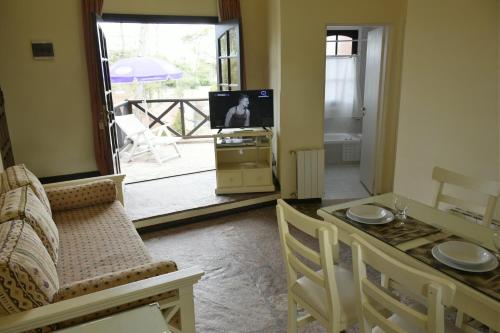 a living room with a couch and a table and a television at Apart Hotel Las Hadas Carilo in Carilo