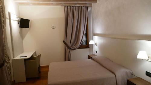 a hotel room with a bed and a window at Hotel La Valle in Volta Mantovana