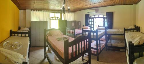 ein Zimmer mit einem Haufen Etagenbetten darin in der Unterkunft Pousada Alojaki Hostel in Praia Grande