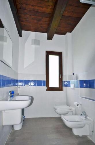 a white bathroom with two toilets and a sink at Casa Mario Spacious Garden Apartments, Lake Como in Domaso