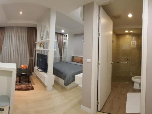 um quarto com uma cama e uma casa de banho com um chuveiro em Chic seaview @ The Patio Bangsaen em Ban Bang Saen (1)