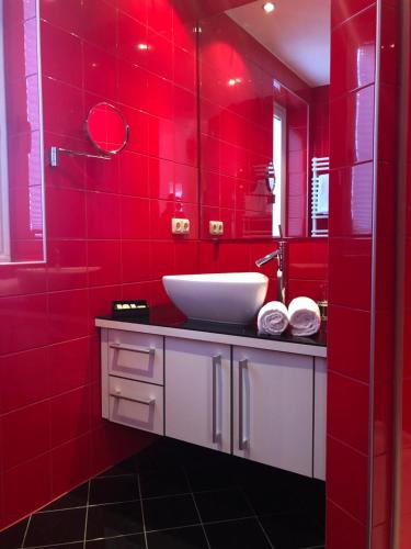 Baño rojo con lavabo y pared roja en Appartements Maria Theresia, en Serfaus