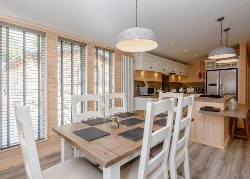 a kitchen and dining room with a wooden table and chairs at Alder Country Park in North Walsham