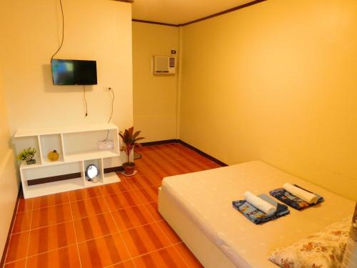 a small room with a bed and a tv at CUADRO INN in General Luna