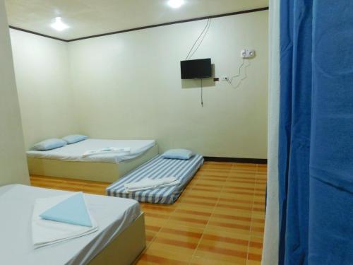 a room with two beds and a tv in it at CUADRO INN in General Luna