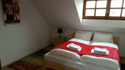 a bedroom with a large bed with a red blanket at Arácsi Vendégház in Balatonfüred