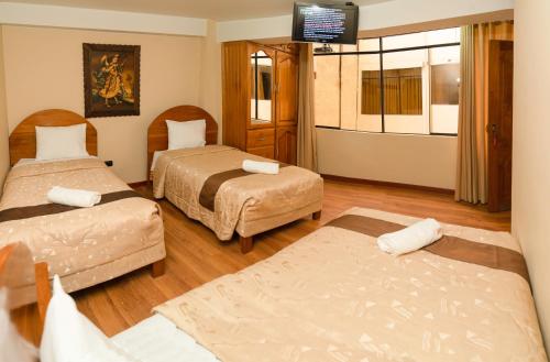 um quarto de hotel com duas camas e uma televisão de ecrã plano em Hotel Melanys em Cusco