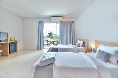 a hotel room with two beds and a television at Lemonade Phuket Hotel -SHA Plus in Chalong