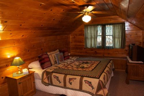 a bedroom with a bed in a log cabin at Sleepy Forest Cottages in Big Bear Lake