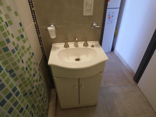 y baño con lavabo blanco y ducha. en Puerto Termas en Colón