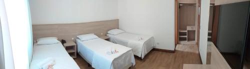 a room with two beds and a mirror at Serrano Hotel in Ribeira