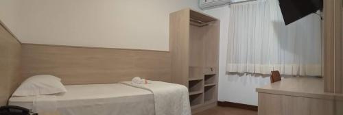 a small room with a bed and a window at Serrano Hotel in Ribeira