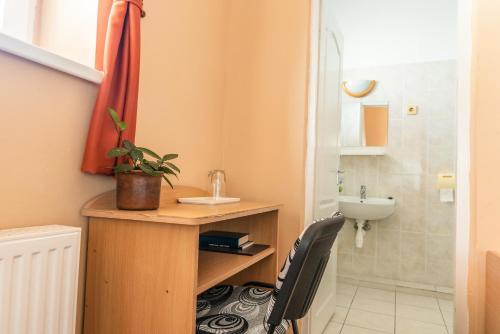 a small bathroom with a desk and a sink at Huszár Panzió és Étterem in Sárospatak