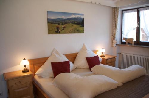 een woonkamer met een bank met kussens bij Bergbauernwirt im Landhaus Bolgental in Bolsterlang