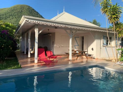 a villa with a swimming pool in front of a house at Villa Bois d'Inde in Le Diamant