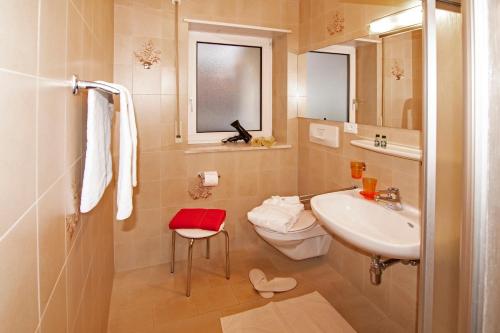 ein Badezimmer mit einem Waschbecken, einem WC und einem Spiegel in der Unterkunft Alpina Residence in Naturns